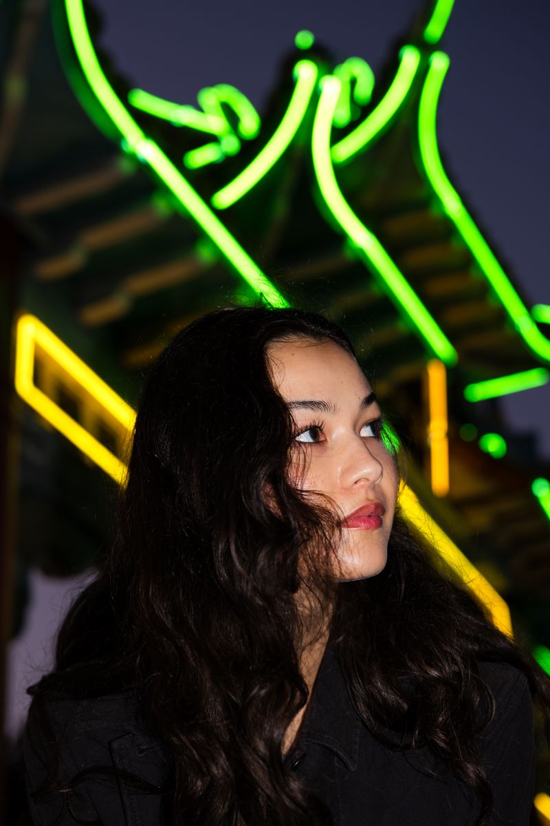 Portrait of a woman lit by colorful neon signs at night