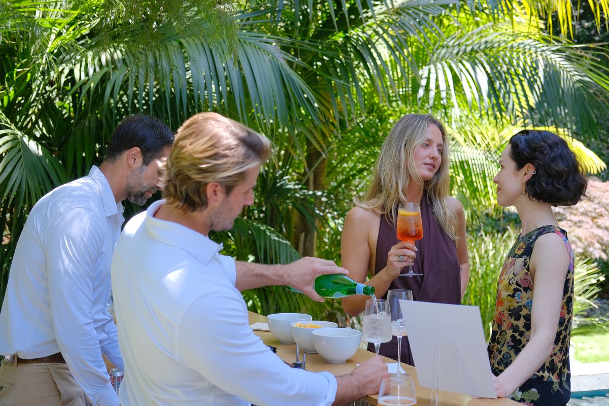 A man pouring champagne for a woman outdoors