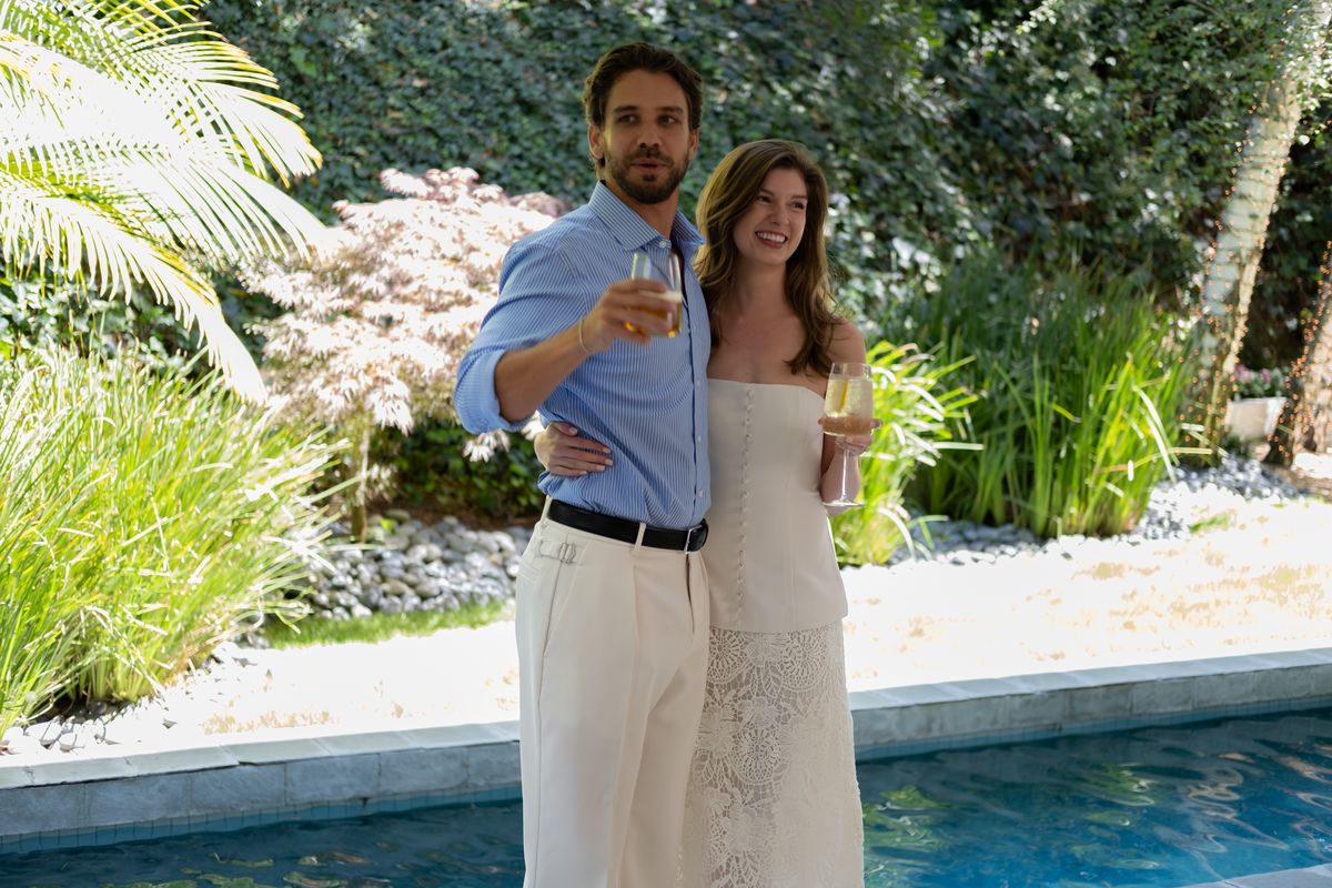 A couple toasting with drinks outdoors among palm trees