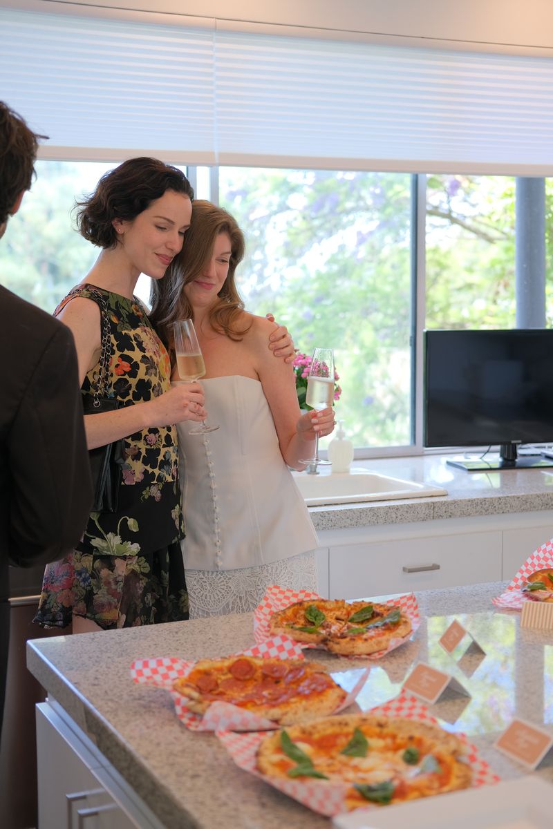 A woman laughing while looking at her phone in a bright kitchen