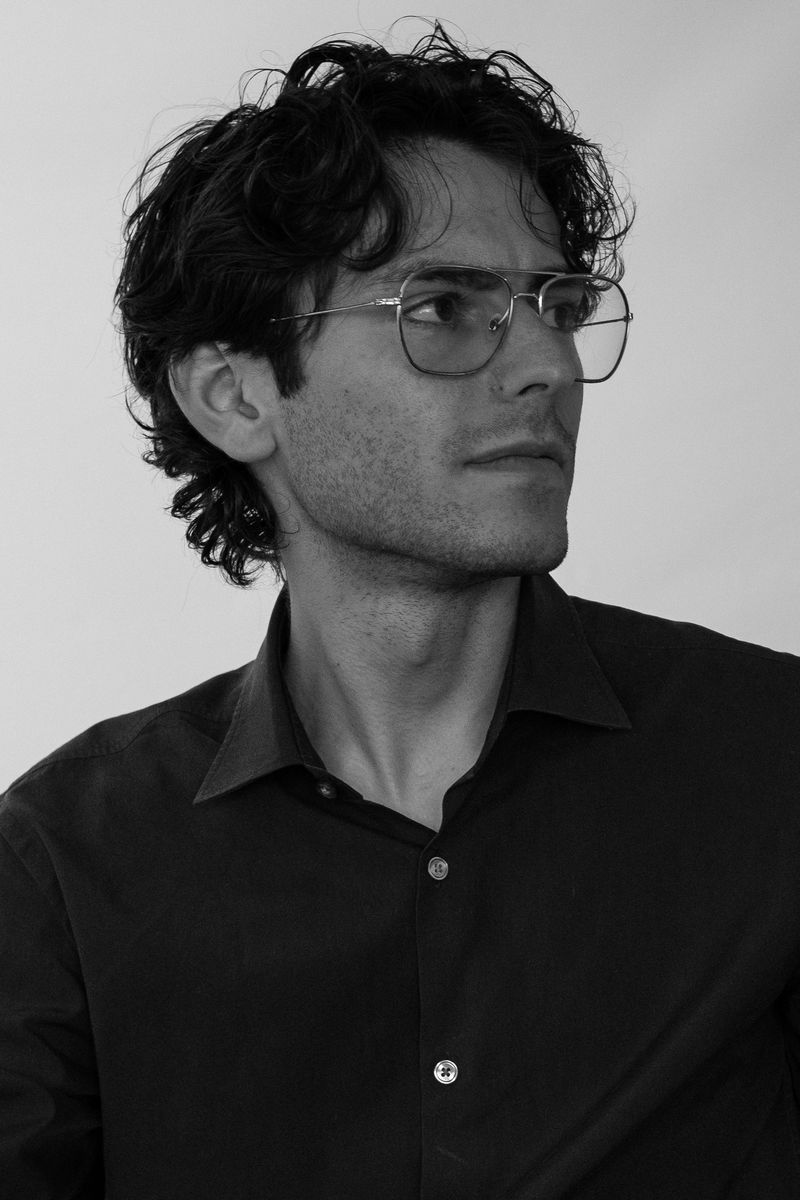 Black-and-white portrait of a man in glasses looking to the side