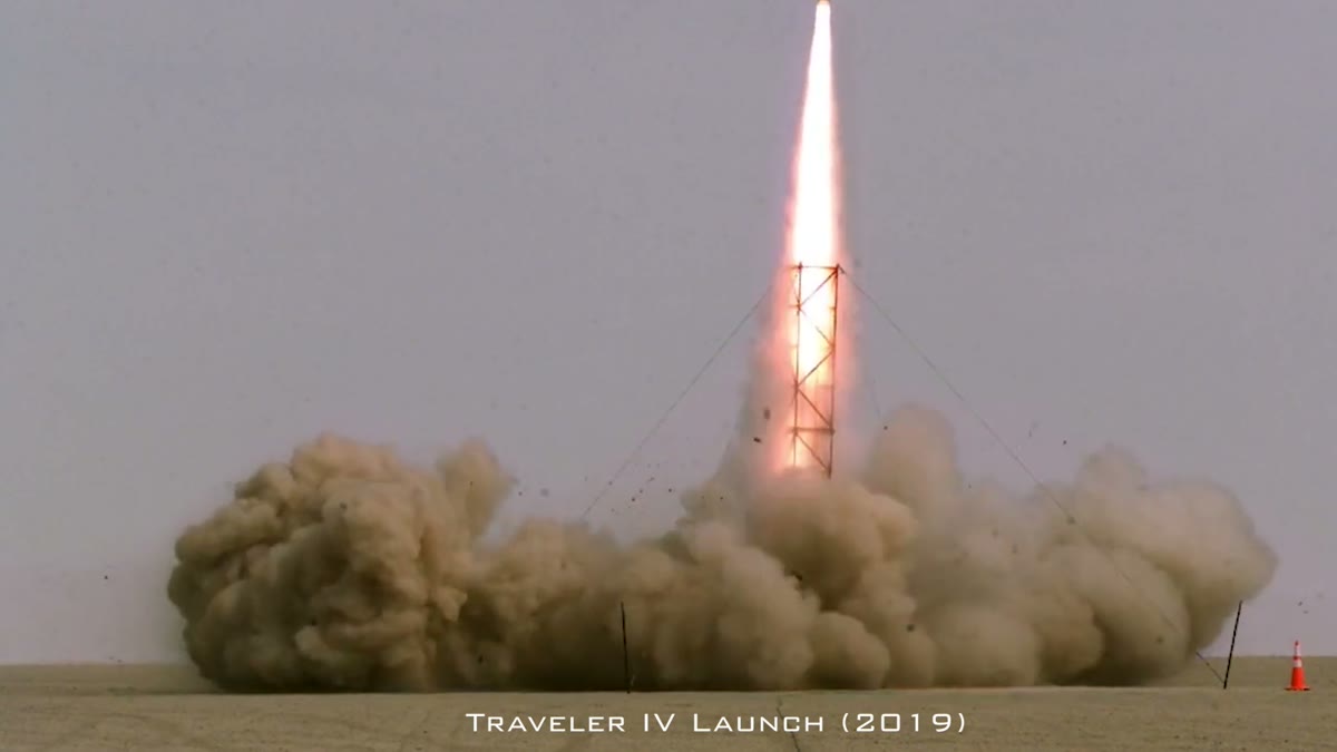 A rocket launching in a plume of smoke and flame against a grey sky, captioned 'Traveler IV Launch (2019)', a still from Fireball